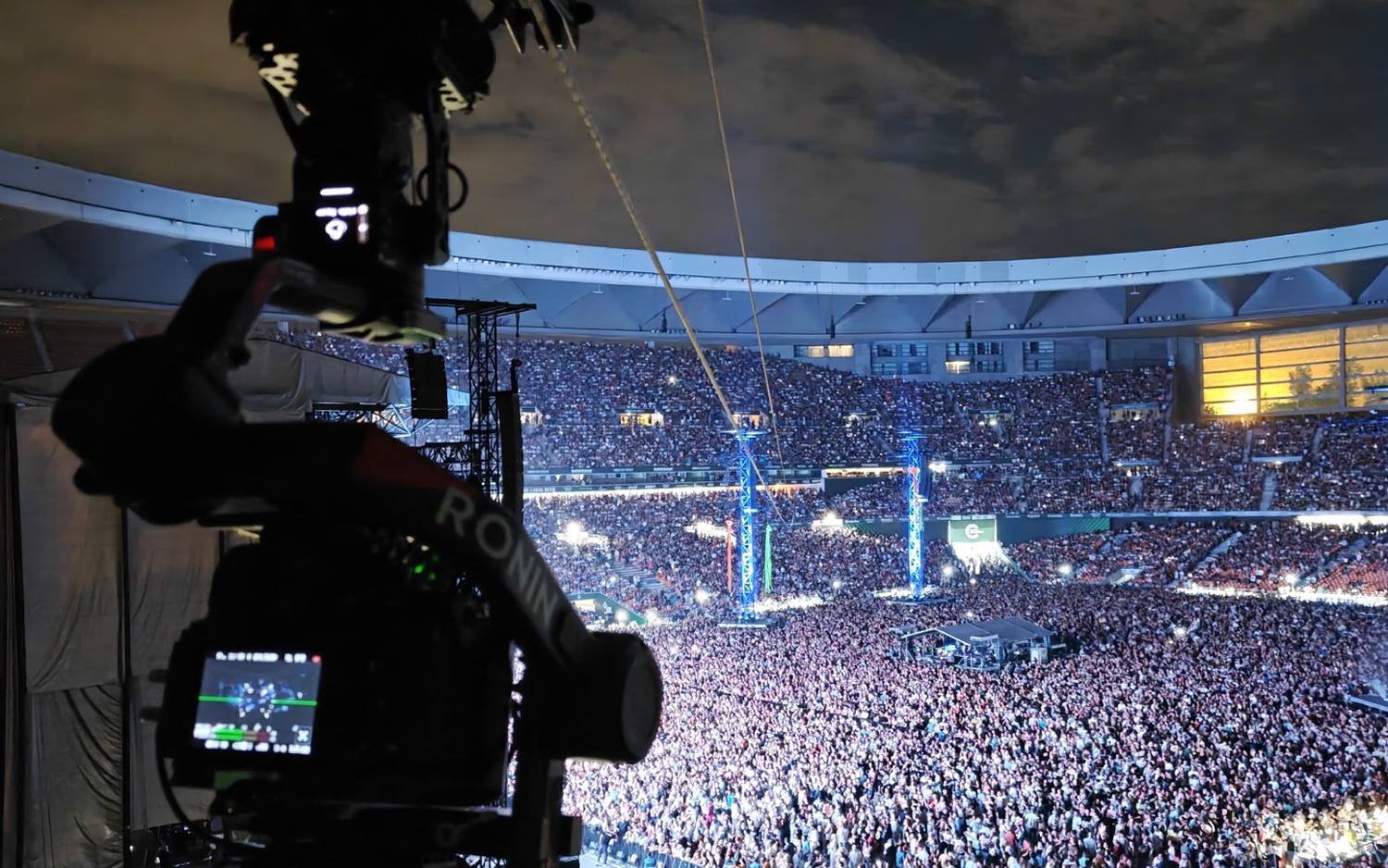 Cablecam de Linecam cruzando un estadio lleno durante un concierto, visto desde la grada